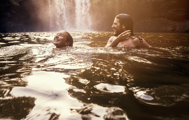 Shot of a young couple swimming together in a lake